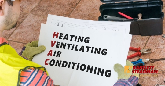 A technician holding HVAC sign.